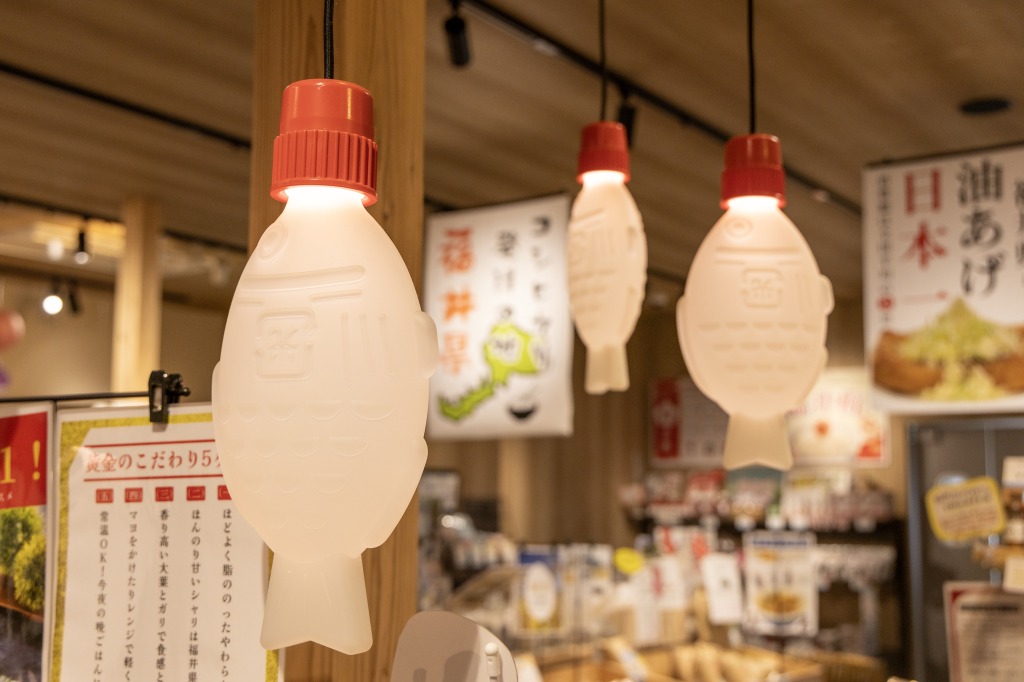 里エリアの総菜コーナーには、魚のしょうゆ入れの形をしたユニークな照明がずらり
