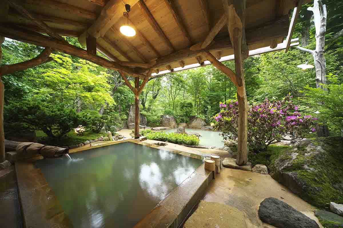 異なる源泉をブレンドした露天風呂「蒼 の湯」は、硫黄と鉄分が混ざり合う、珍しい緑褐色の湯