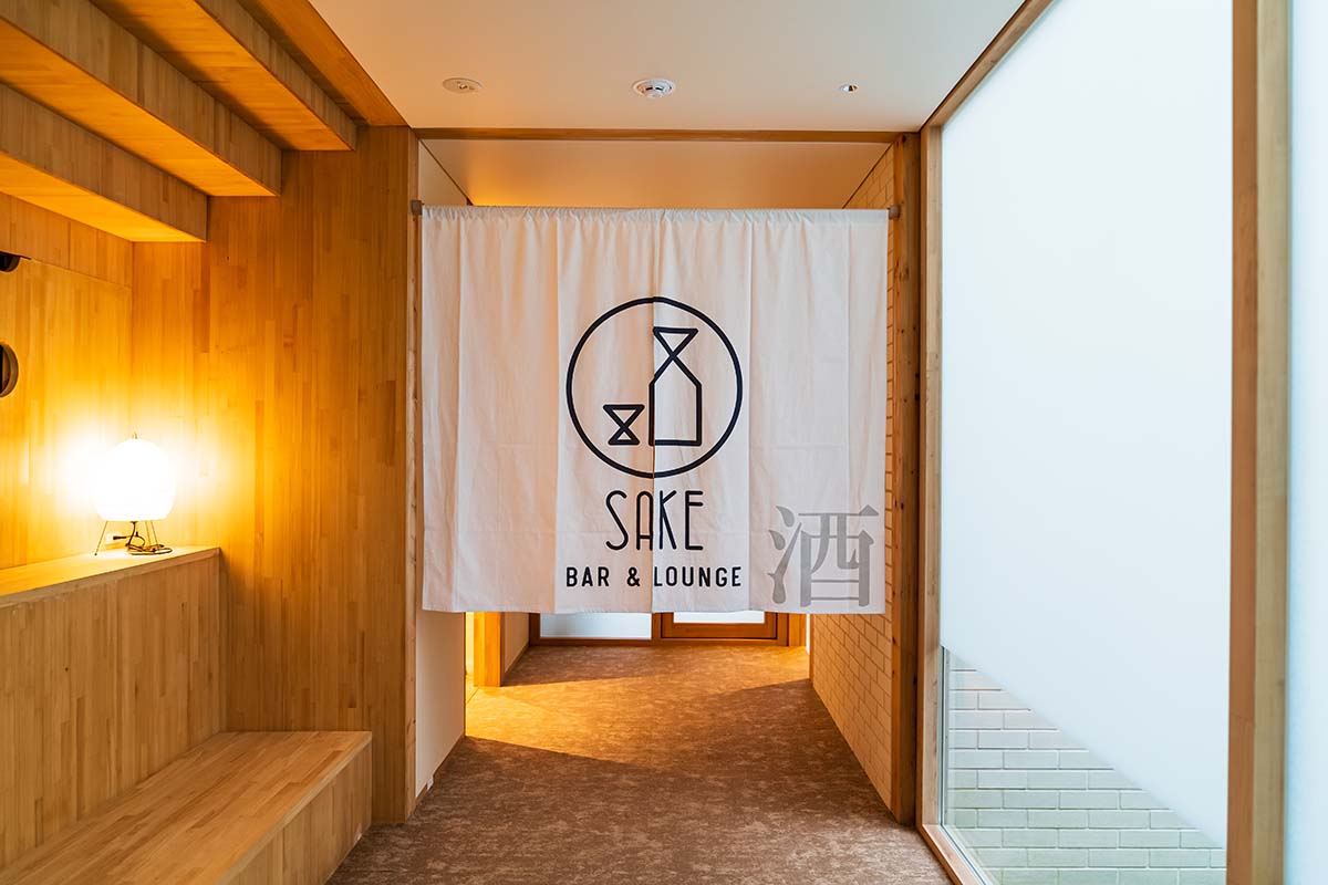暖簾がかわいい、「SAKE BAR ＆ LOUNGE」への入口。「SAKE BAR」は、毎週火・水曜、祝前日は休業