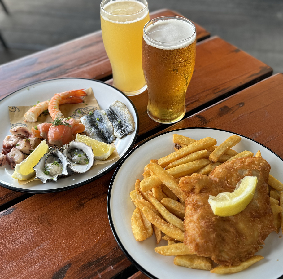 左は牡蠣やタコ、ニシンのマリネ、サーモン、海老のコールドプレート29AU$、右は伝統的なフィッシュ＆チップス17.5AU$、生ビールは12～13AU$