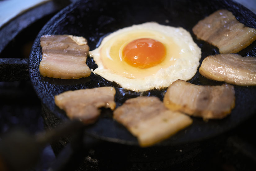 チャパティを焼くフライパンを熱してベーコンと卵を