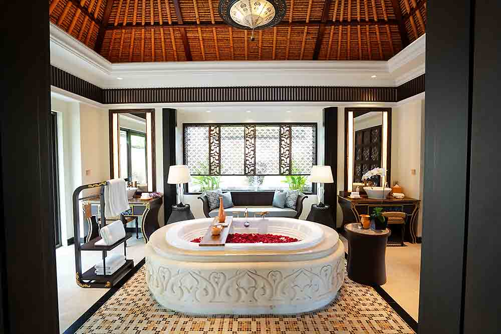 自然光がさし、開放感あふれるヴィラのバスルーム。大理石のバスタブでラグジュアリーな時間が過ごせる。天井には古代インドの叙事詩ラーマーヤナが描かれている