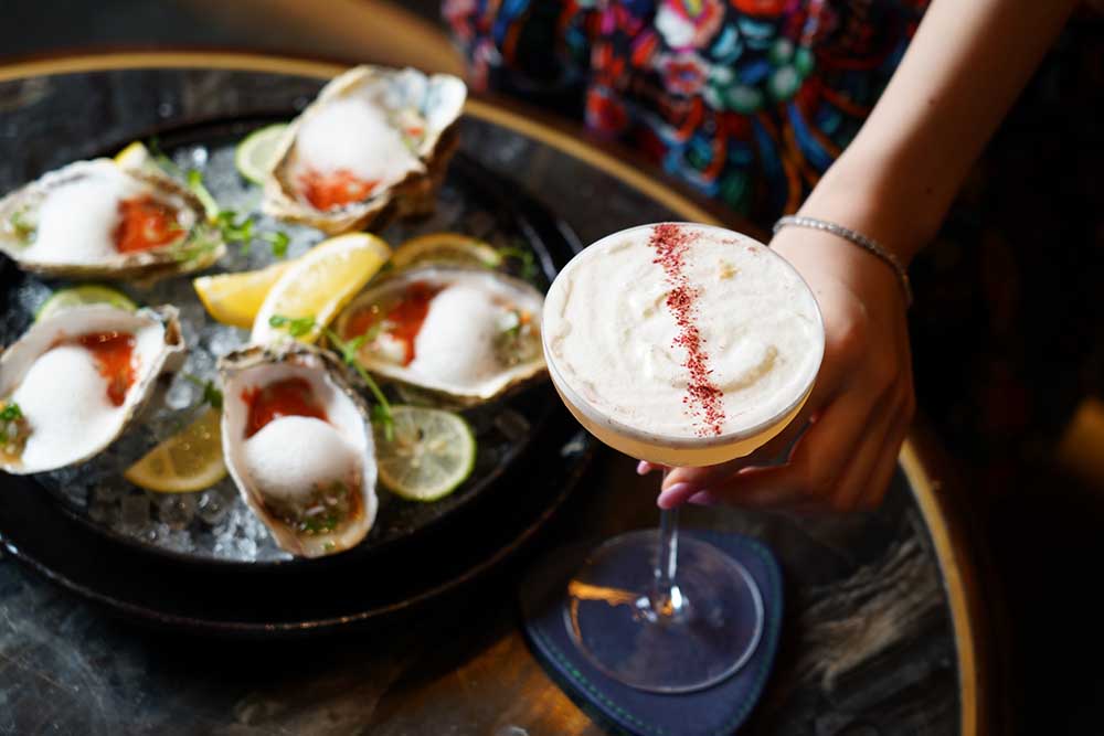 ピリ辛のチリソースと相性抜群なオイスターRp.52万。カクテルはジャスミン、バナナが香るジンベースのアヤナ·ラグジュアリーRp.20万