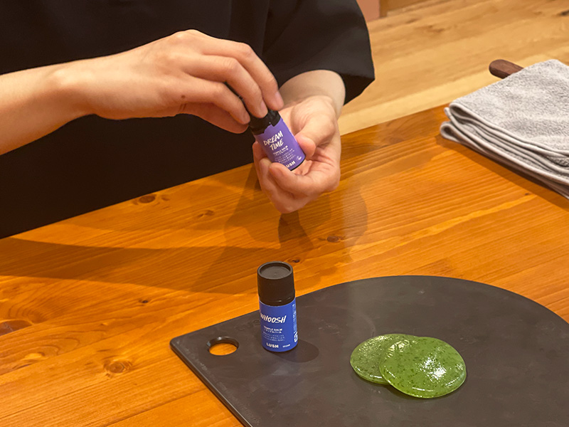 こめかみや首筋などに塗ってリラクシーな気分へと導いてくれる「テンプルバーム」を選ぶシーン