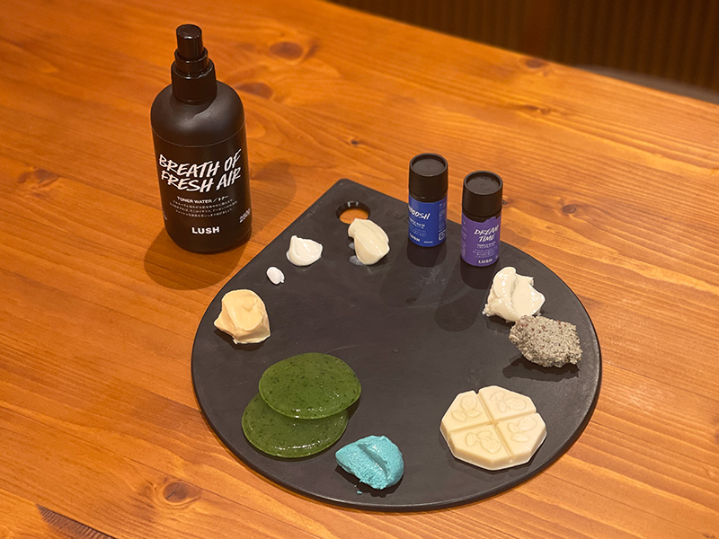 (写真右上のスティックから時計回りに)「ウーッシュ! テンプルバーム 」2040円(テンプルバーム)、「ドリームタイム テンプルバーム」(テンプルバーム)、「ウルトラブランド(俳句)」2020円(クレンジング)、「天使の優しさ」2140円(洗顔料)、「アルゲーロフェイシャルオイル」1970円(フェイシャルオイル)、「ドント ルック アット ミー」1990円(フェイシャルマスク)、「Q アイパッド」770円(アイパック)、「スイートワイルドシトラス」1680円(ハンドクリーム)、「魅せられて」4110円(アイクリーム)、「コスメティック フレンド」4110円(保湿クリーム)、「バイオミク」2270円(ボディクリーム)、「オーシャンヴェールウォーター」1630円(化粧水)