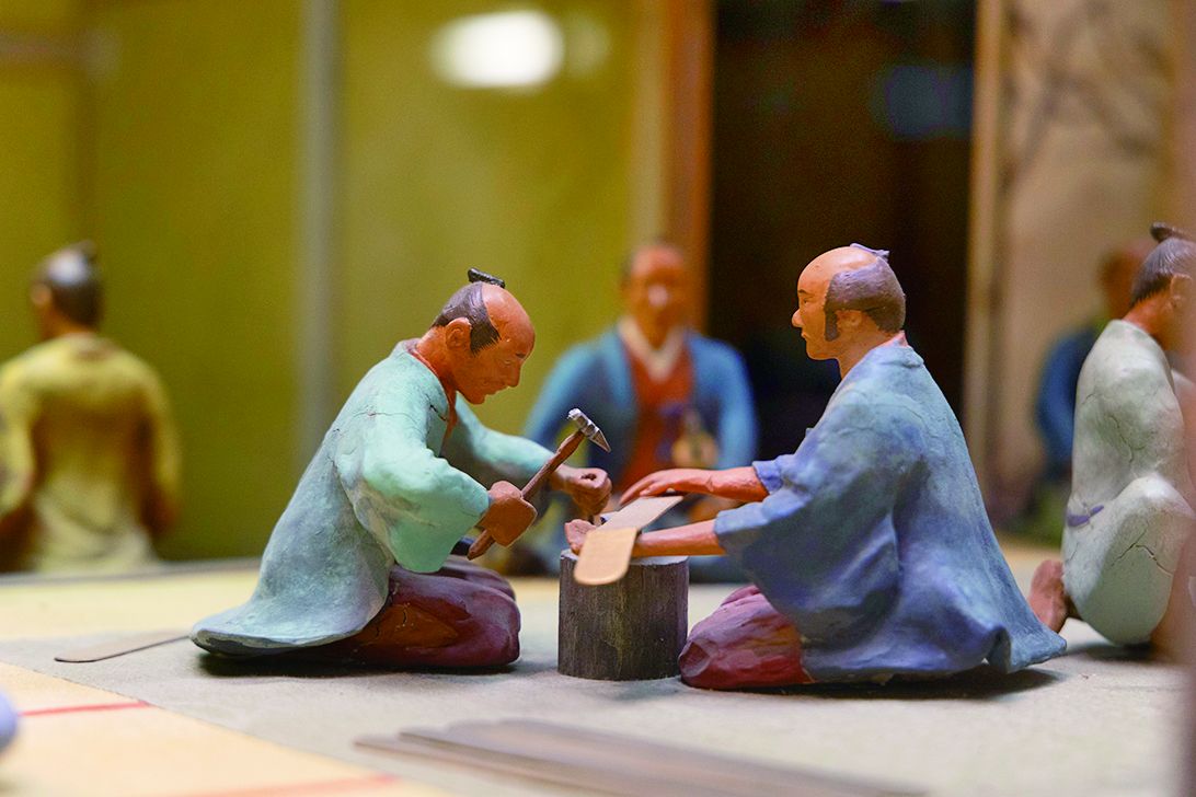 金の延板を槌で叩き小判にする様子