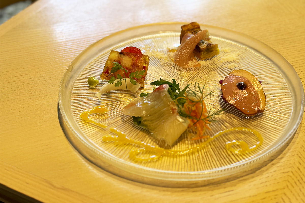 （左上から時計回りに）魚介のテリーヌ、キノコとベーコンのキッシュ、鴨肉と紫タマネギのマリネ、白身魚のカルパッチョ