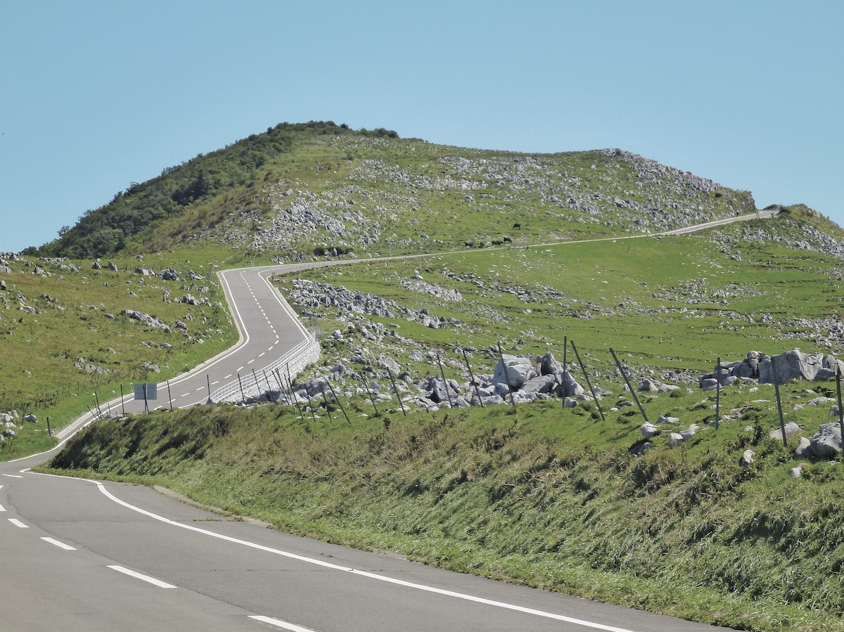 白い石灰岩が点在する台地に、空へ向かうようなアスファルト舗装が続く