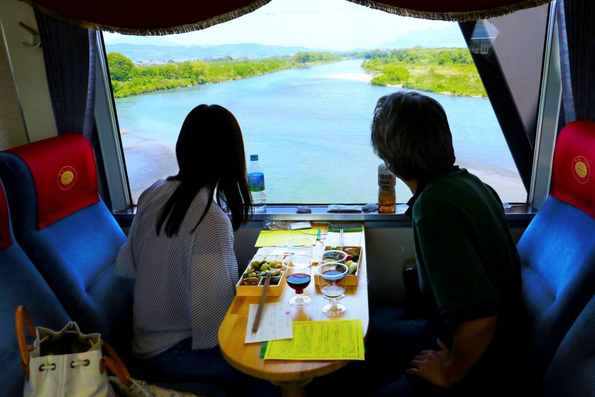 千曲川を渡り田園風景の中を行く北信濃ワインバレー列車