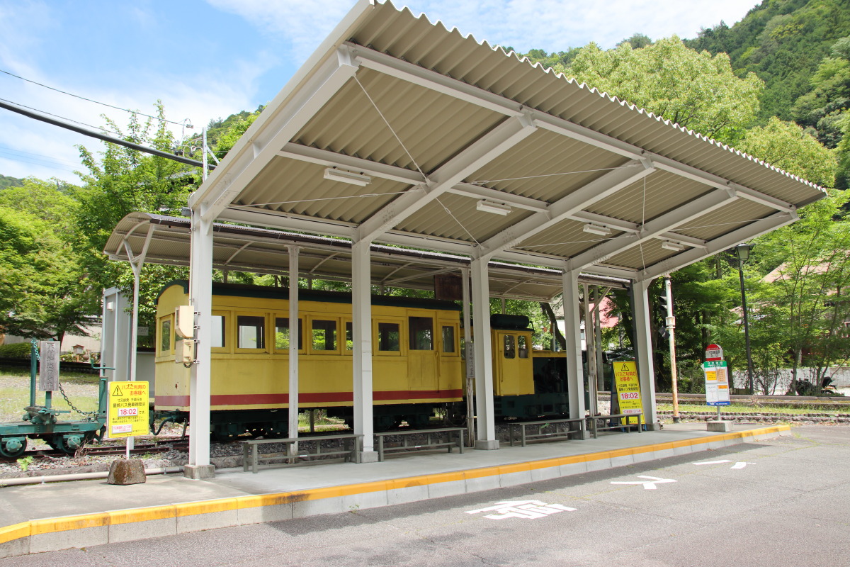 寸又峡温泉入口のバス停。かつてこの地を走っていた森林鉄道のトロッコ列車が展示されている