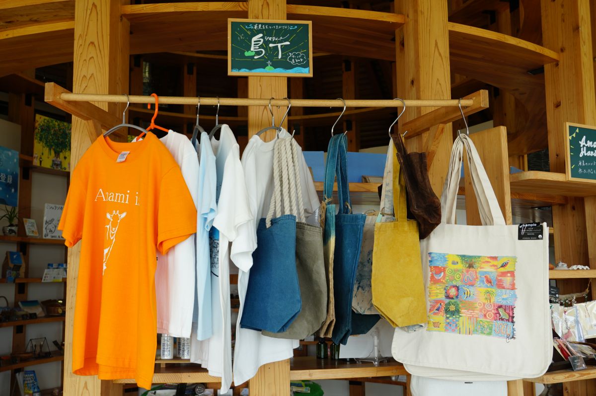 奄美の動物や植物などをモチーフにしたデザインのTシャツ「島T」。トートバッグも。
