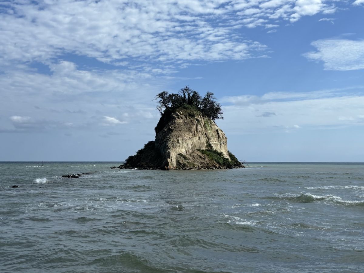 軍艦の舳先の両側に崩れた土砂が積みあがった見附島