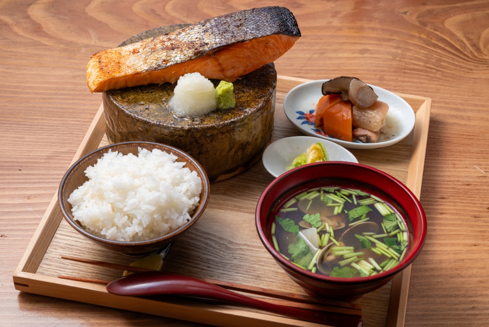 極厚銀鮭定食2500円。がめ煮（筑前煮）など小鉢2品、うま味たっぷりの貝汁が付く