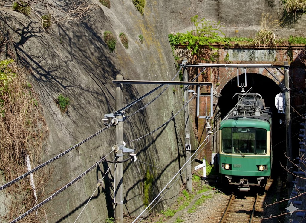 断崖に囲まれた極楽洞を走り抜ける江ノ電