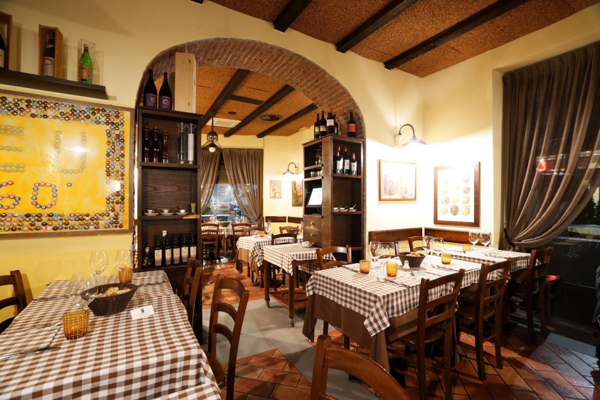 市松模様のテーブルクロスや木製椅子が並ぶ温かみのある空間