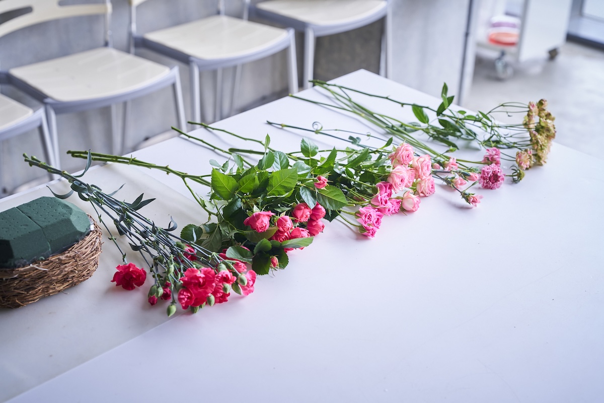 花材は左から、スプレーカーネーション（ホットピンク）、スプレーバラ（カンタービレ）、スプレーバラ（ストロベリーポロン）、スプレーバラ（ピンクワルツ）、スプレーカーネーション（ミニティアラピンク）、スカビオサ（サーモンQ）、スプレーバラ（コンフェイト）