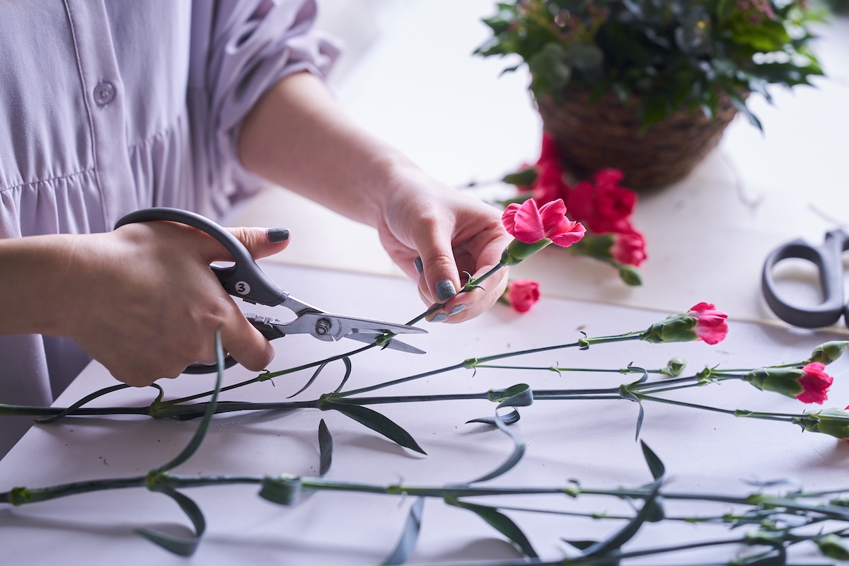 スプレーカーネーションをハサミで切る中條さんの手元