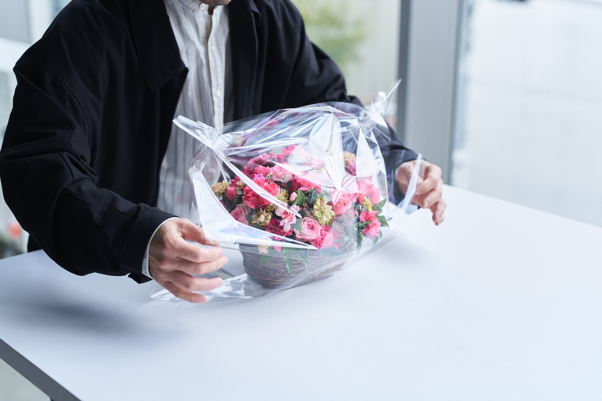 完成したアレンジメントをラッピングする西垣さんの手元
