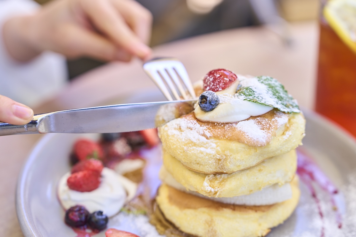 パンケーキにフォークとナイフを入れている様子