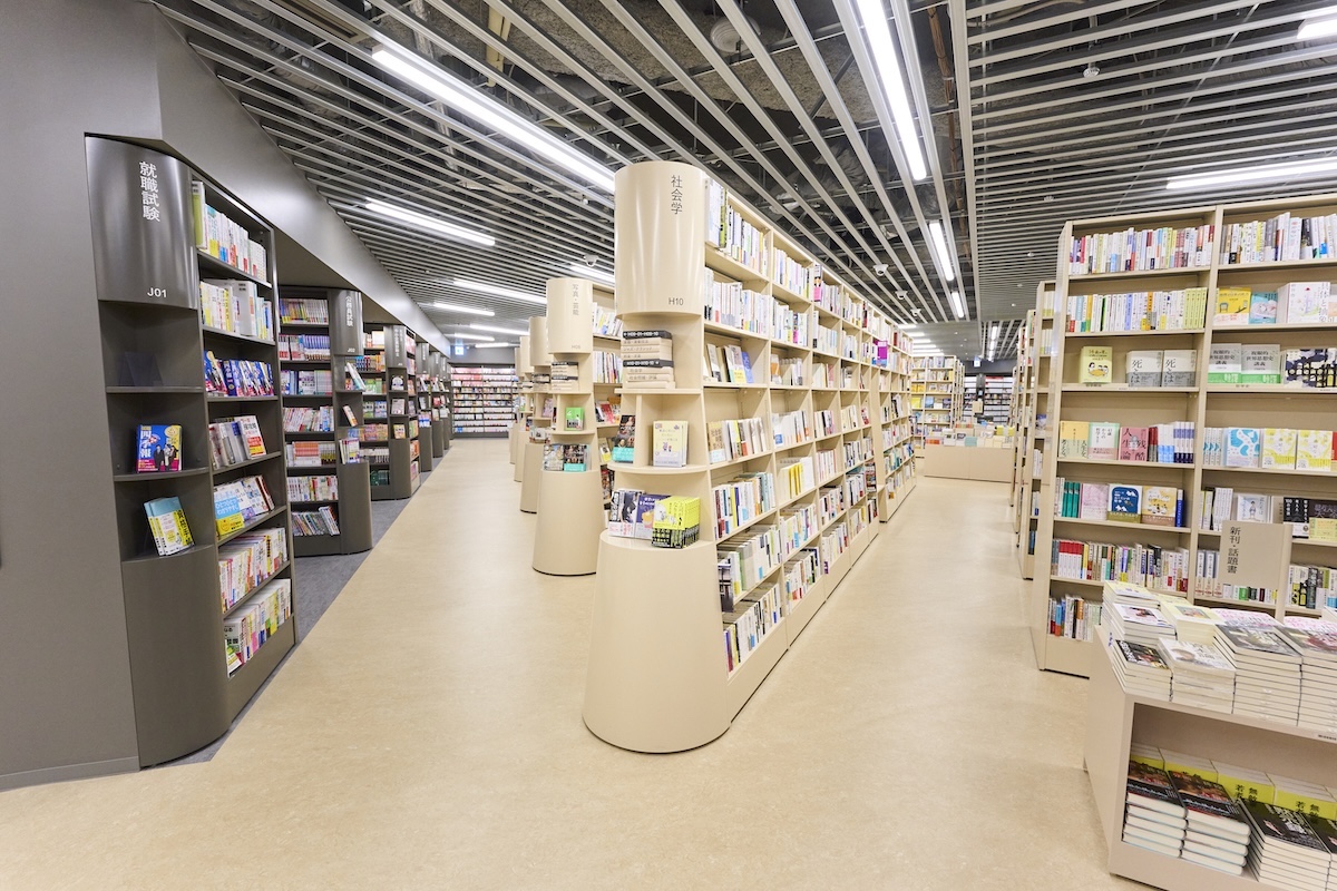 ベージュの書棚が「発見のさざ波」で、それを囲むグレーの棚が「探求の洞窟」。新書と文庫が並ぶ