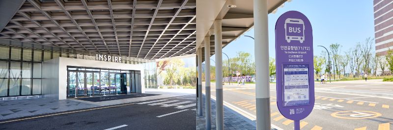 メインロビー(左)の向かい側に見えるバス停（右）。紫の時刻表を見つけて