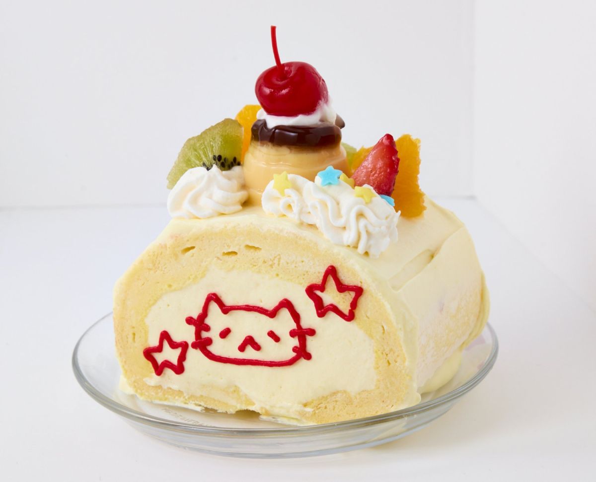 「プリンアラモードロールケーキ（バナナクリーム）」 W1万500。ぽてんとしたロールケーキのフォルムにゆるい猫のイラストがたまらなくかわいい。小さなプリンアラモードものった夢のようなスイーツ