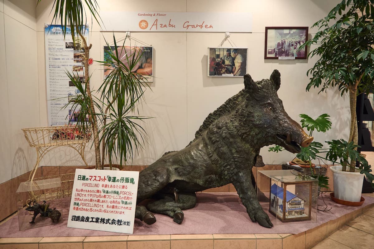 エスカレーターのそばに立つ「幸運の仔豚像・PORCELLINO」