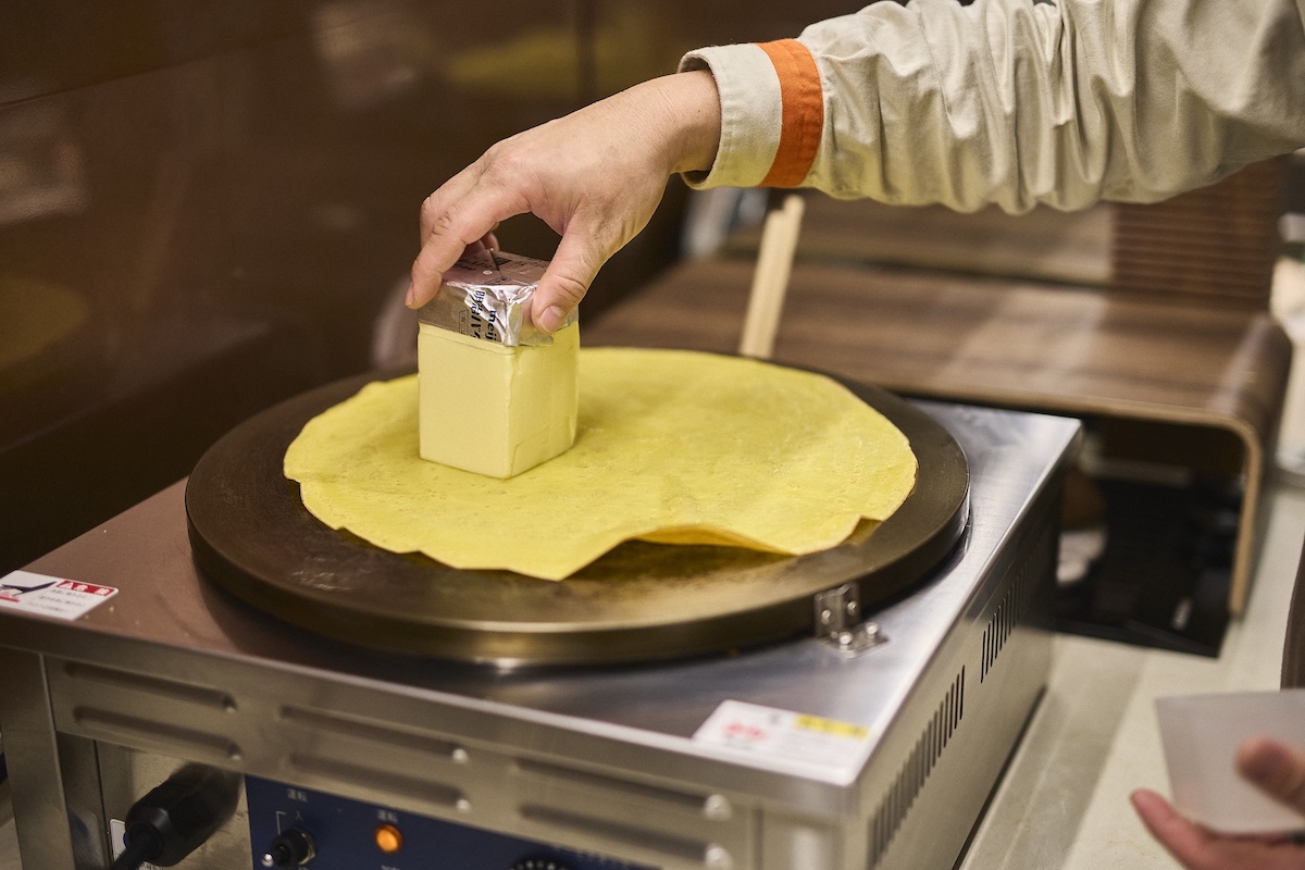 焼き上げた生地にバターを塗る様子