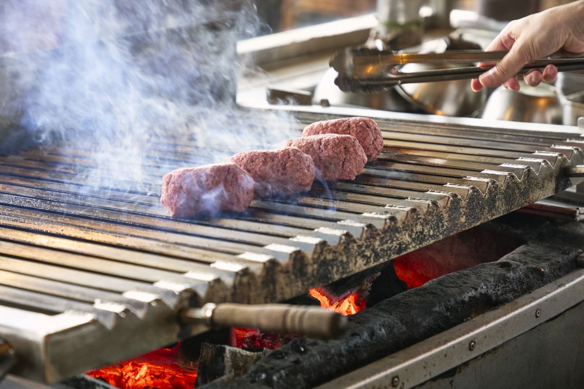 全工程を習得した熟練スタッフが立つ焼き場。肉を焼きながら店内全体を見渡し、ホールと厨房をつなぐ&ldquo;司令塔&rdquo;も担う