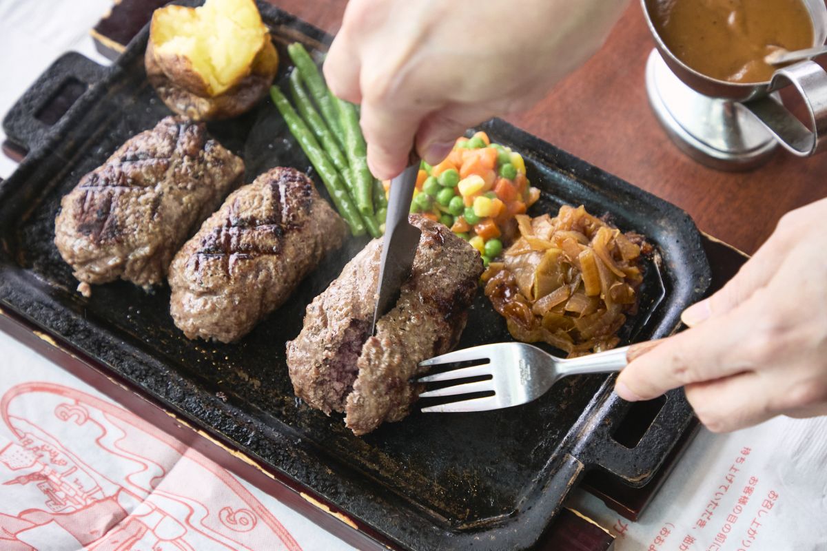 スタッフが客席で半分に切り、鉄板の余熱で焼き上げて完成！