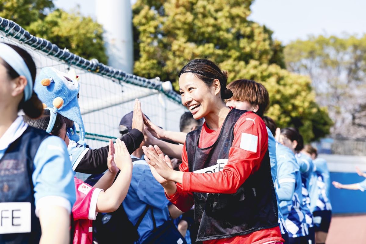 笑顔でファンとハイタッチを交わす田中さん（写真提供：ニッパツ横浜FCシーガルズ）