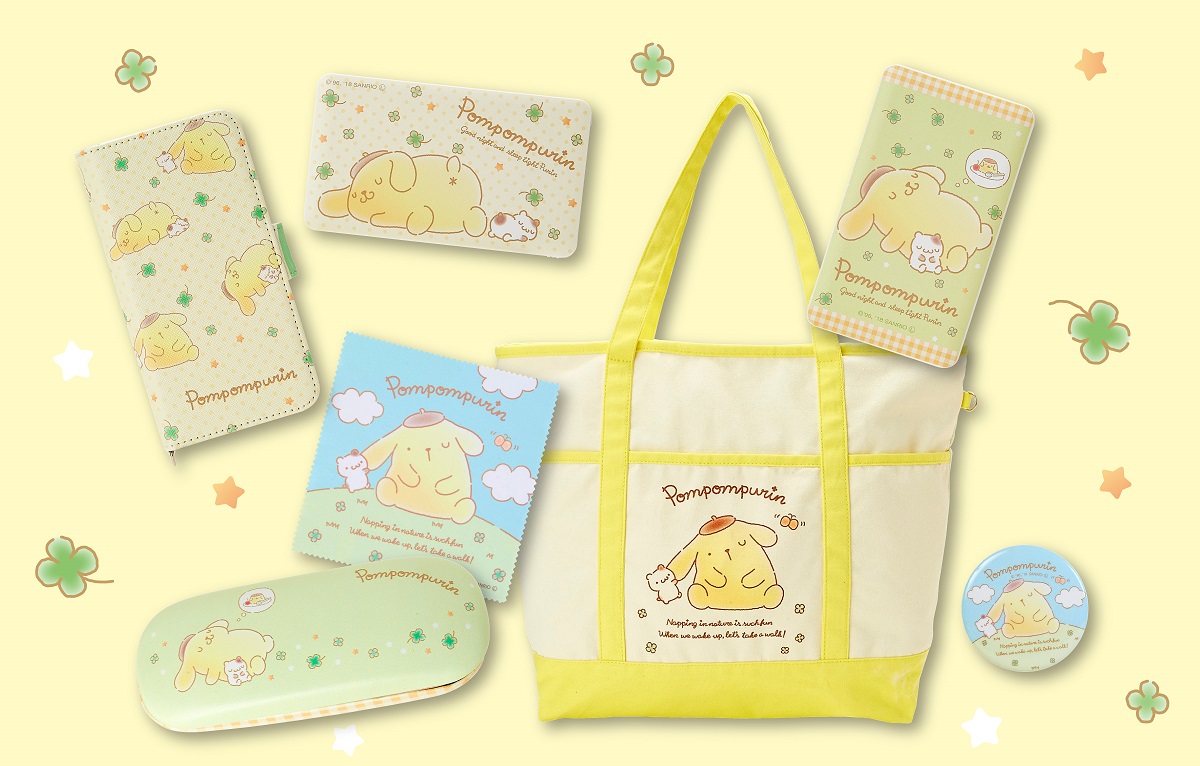 写真左上から「携帯ケース」3000円、「リチウムポリマー充電器」(2種類)各3480円 写真左下から「メガネケース」1200円、「クリーニングクロス」300円、「ビッグトートバッグ」3900円、「缶バッチ」300円 ※いずれも税抜