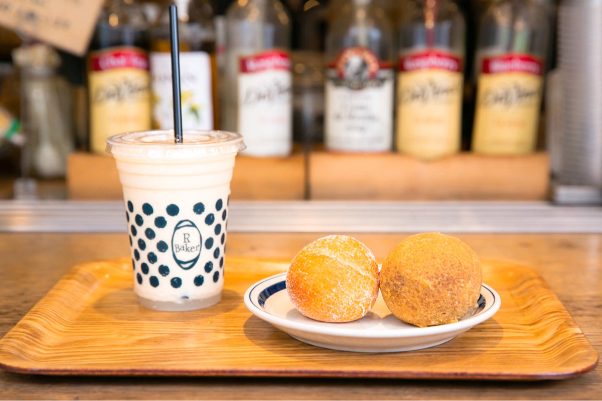 左から桃、パイナップル、バナナ、ミルクのミックスジュースの「スムージー」500円、「スフレチーズドーナツ」97円、「もちもちきなこ」97円