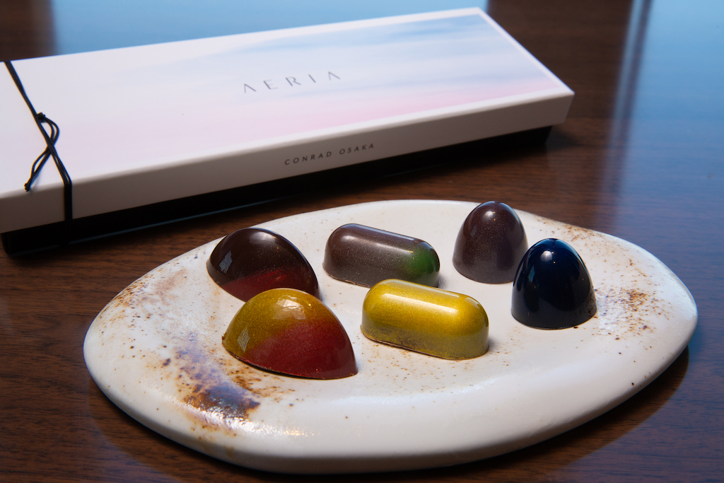 奥：グランクリュ・チョコレートボンボン（左からオコア70%、アルンガ41%、アルトエルソル65%）／手前：コンラッド大阪オリジナルチョコレートボンボン（左からSUNSET、GOLDEN SUN、NIGHT SKY）6個入り2916円（イートインは1粒540円～ ※サ別）