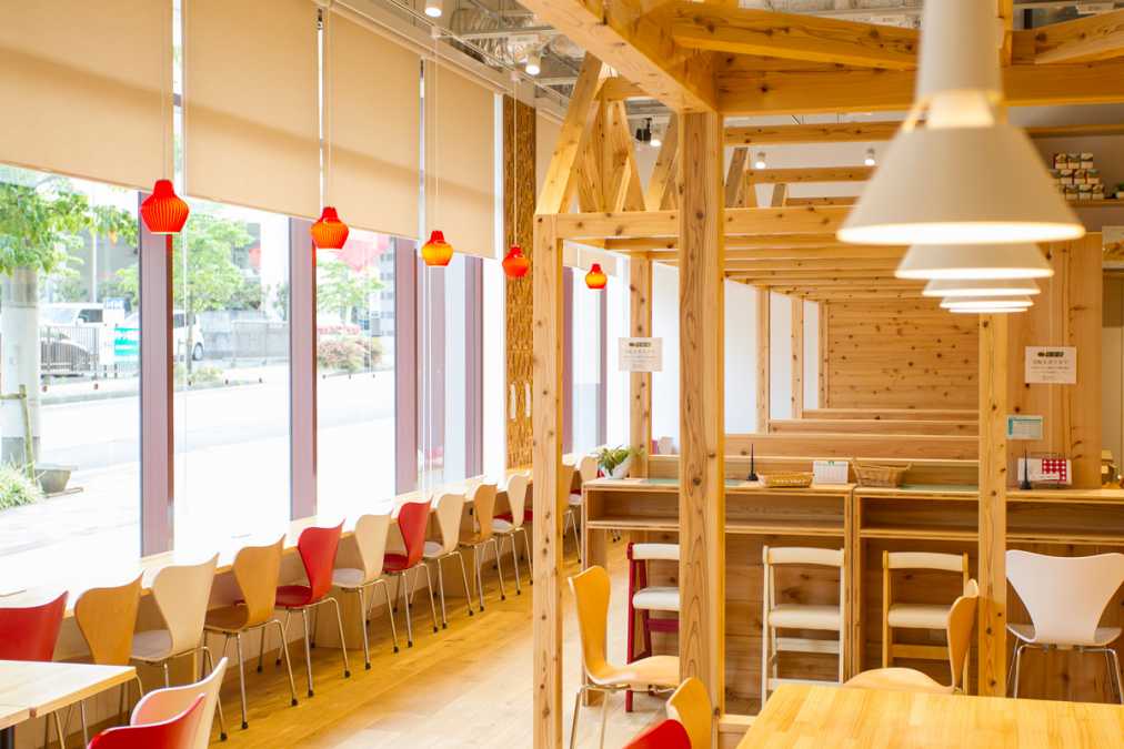 木材をふんだんに使い、赤をアクセントカラーにしたカフェスペース