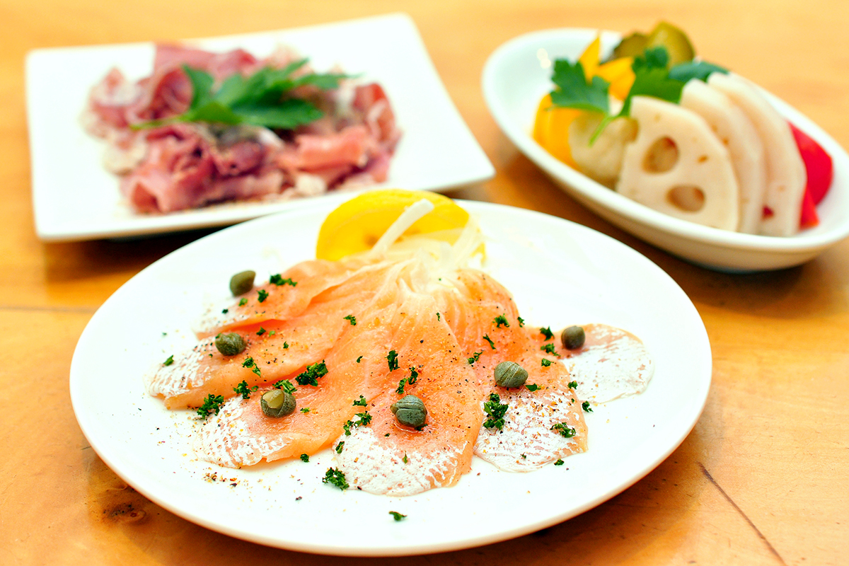 サーモン燻製塩仕立て（手前）イタリア産プロシュートの切り落とし（左）野菜の自家製ピクルス（右）