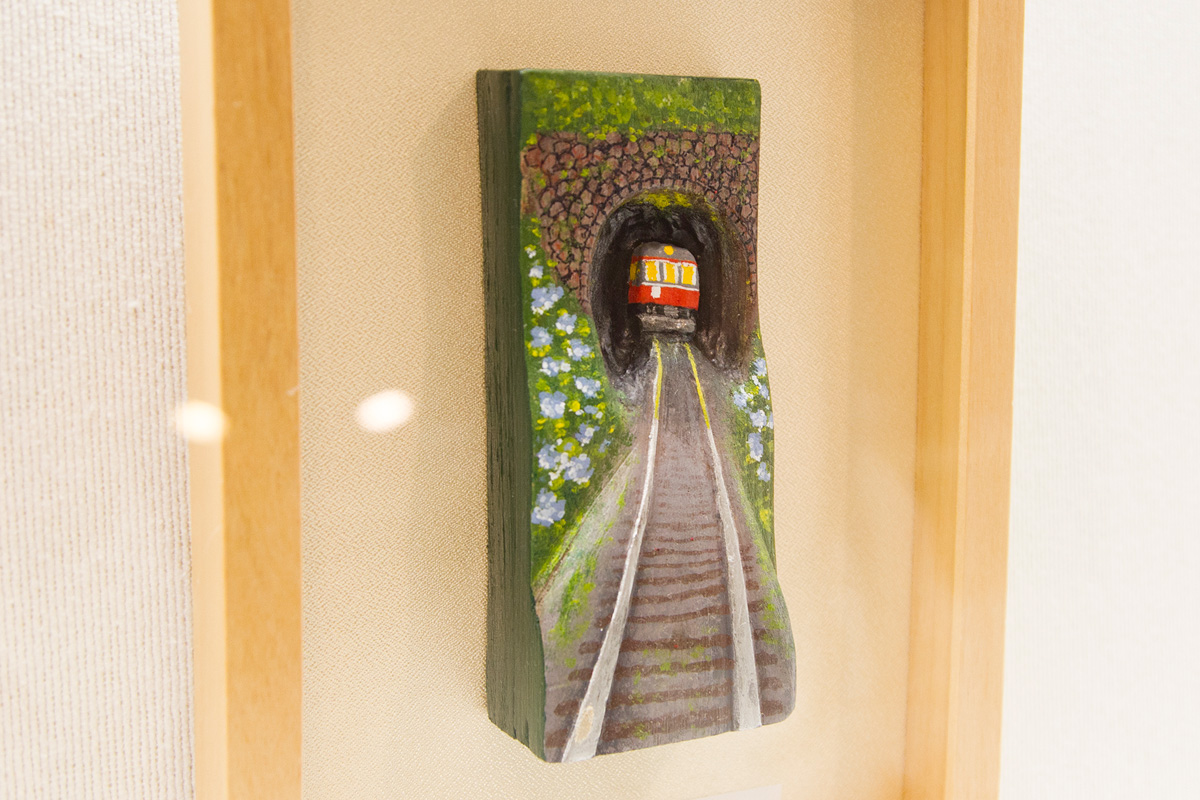 板の厚みを調整して、走る列車や線路の遠近感、立体感を表現した作品