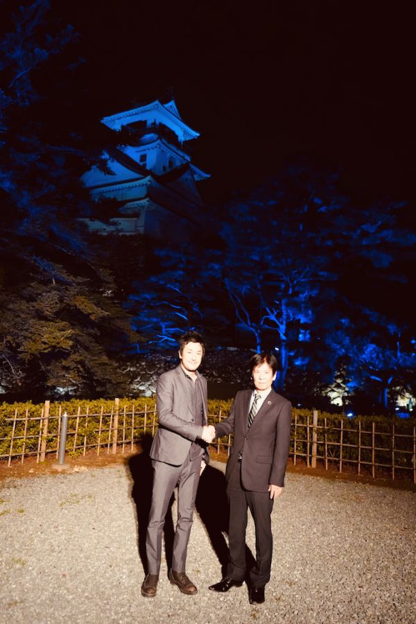 記者会見で握手を交わす高知県副知事の岩城孝章氏と、チームラボ代表の猪子寿之氏